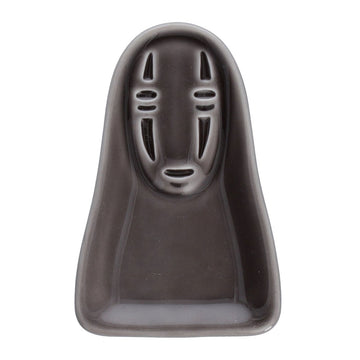 Gray mask-shaped container on a white background. Ceramic condiment dish in the shape of No Face from Studio Ghibli's Spirited Away.